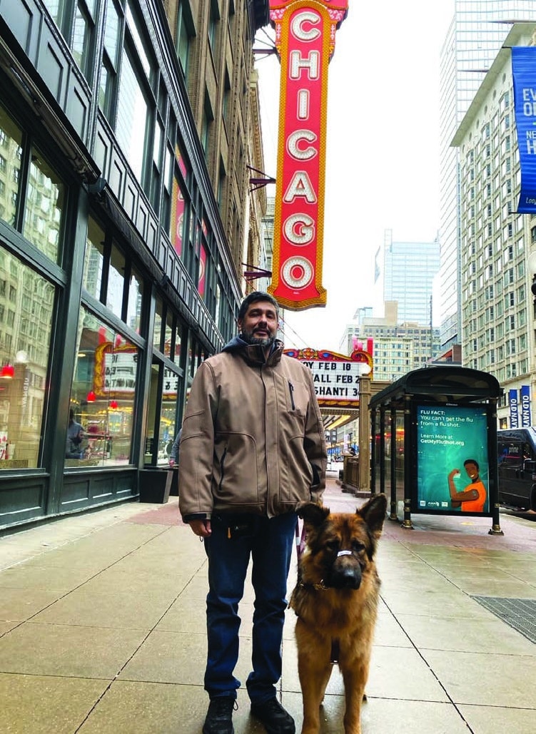 Miguel standing with Iron with Chicago sign in back.