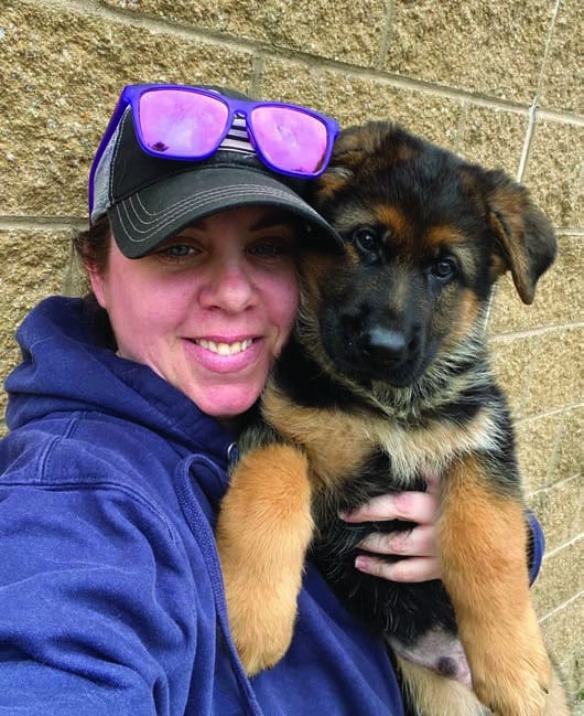 Liz taking a selfie while holding Rebel, a 8-week-old pup in her hand.